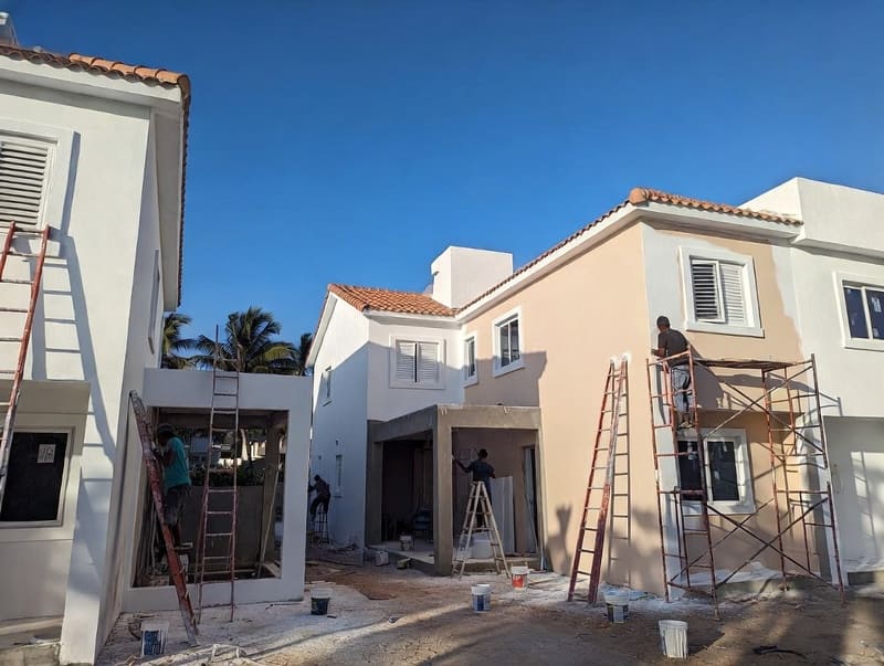 Pintores Punta Cana trabajando en fachadas de casas y apartamentos en Bávaro, aplicación de pintura exterior resistente al sol y humedad